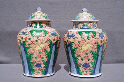 A pair of Chinese wucai 'galloping horses' vases and covers, Transitional period